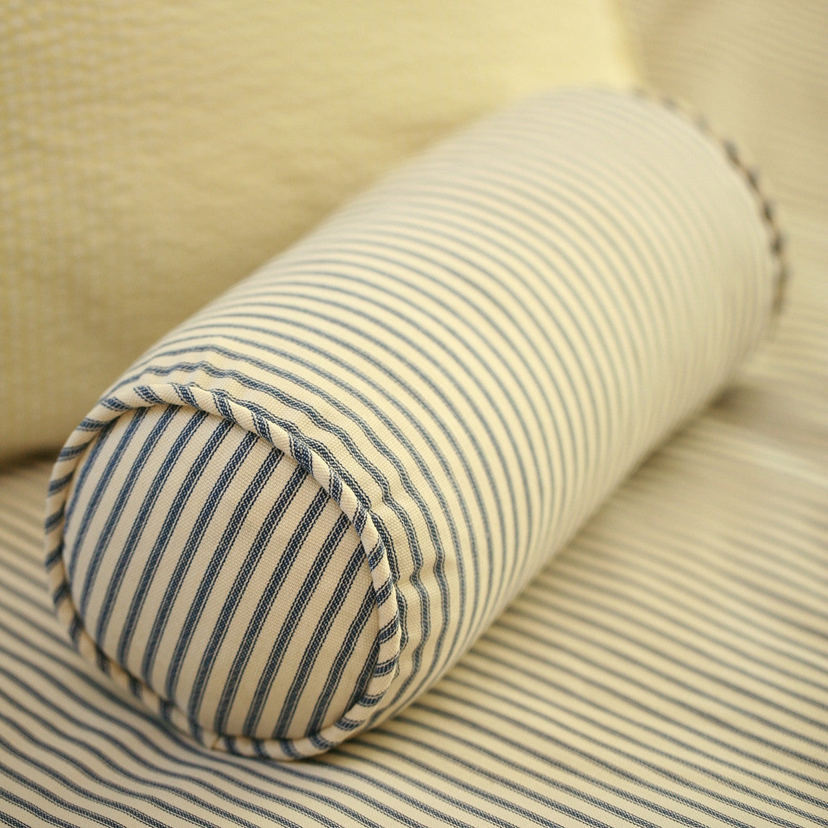 Navy Blue Ticking Stripe Bolster Neckroll Pillow on Blue striped bed